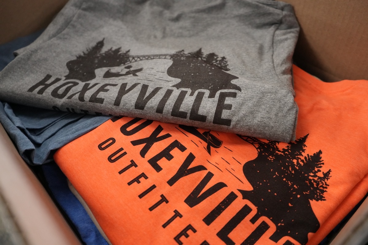 Hoxeyville Outfitters custom tees in two colorways packed in a shipping box